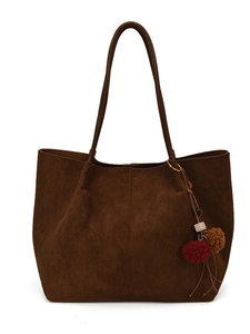 Brown faux suede tote bag with long straps and tassel charm in a front-facing view