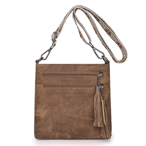 Detailed close-up of brown vintage crossbody bag with zippers and retro fringe charm