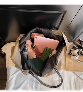 Spacious interior of khaki tote bag showing storage for laptop, phone and accessories