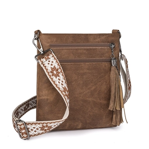 Brown crossbody bag detail featuring woven strap with patterns and a large tassel charm