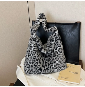 Détail du grand sac cabas en fausse fourrure léopard gris posé sur un fauteuil noir