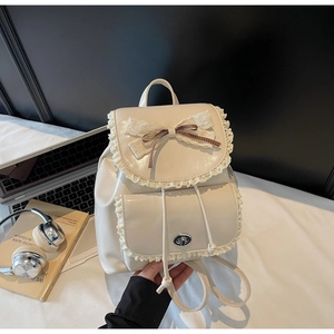 Close-up of cream vintage backpack featuring delicate lace edges and ribbon bow detail