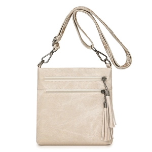 Detail of off-white crossbody bag with double zippers, long tassels and woven strap