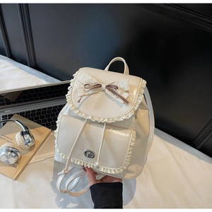 Close-up of cream white PU leather backpack featuring lace edges and ribbon bow details
