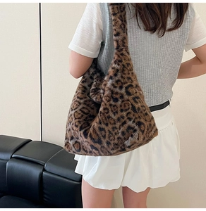Détail du sac à bandoulière en peluche léopard porté par un mannequin sur l'épaule