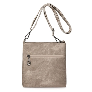 Detail view of khaki washed canvas crossbody bag showing metal zippers and strap texture