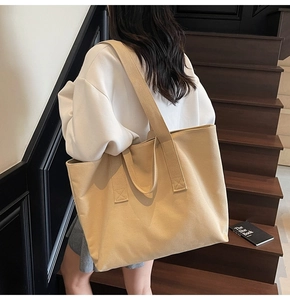 Detail of spacious beige canvas tote bag with thick shoulder straps for daily use