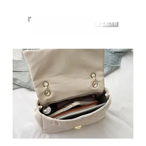 Spacious interior of beige quilted bag with chain strap showing multiple storage pockets