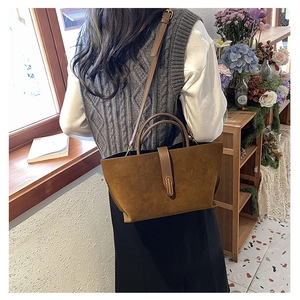 Brown frosted suede tote bag with metal buckle closure shown in a vintage lifestyle setting