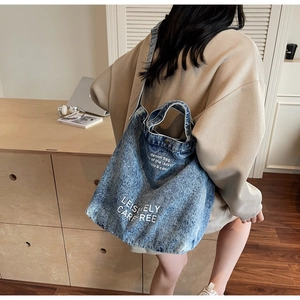 Detail view of denim tote bag with Leisurely Carefree print and adjustable shoulder straps