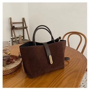 Detailed view of vintage matte tote with brown leather straps and gold metal oval buckle