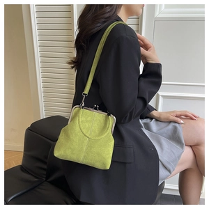 Detail of avocado green frosted leather crossbody bag with vintage metal clip closure