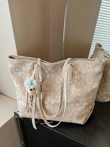 Große beige Tragetasche mit Blumenmuster und blauem Bärenanhänger für Damen im Alltag