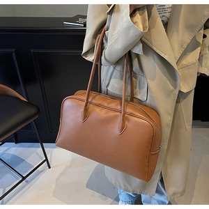 Borsa a spalla marrone in finta pelle martellata con manici sottili indossata da modella