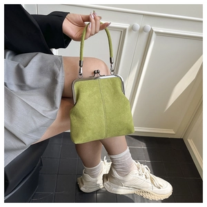 Detail of vintage grass green suede shell bag with classic metal kiss-lock clasp