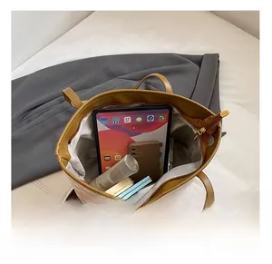 Macro view of brown leather tote bag interior showing capacity for tablet and daily items