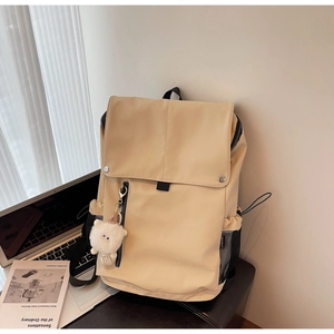 Detail of beige nylon backpack with silver snap buttons and a cute cat charm pendant