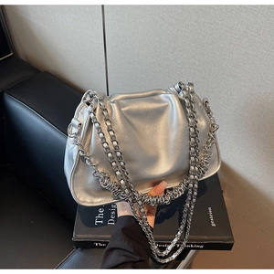 Detail of silver pleated shoulder bag with metallic finish and woven chain strap