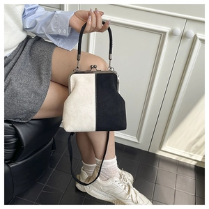 Detail of retro clasp handbag with black and white contrast leather and silver metal frame