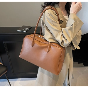 Dettaglio di una grande borsa a spalla in pelle martellata marrone per il lavoro