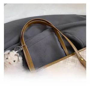 Detail of beige plaid tote with brown leather handles and plush charm accessory