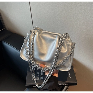Detailed view of fashionable metallic silver pleated bag with silver chain straps