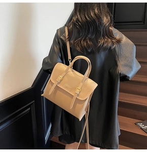 Detailed view of beige leather backpack with golden buckles and minimalist straps
