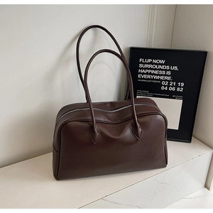 Primo piano di una grande borsa Boston in pelle marrone su marmo con cerniera argentata