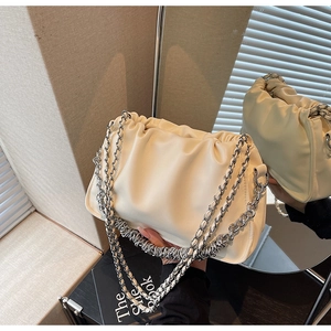 Detailed view of cream-colored pleated cloud bag with multi-layer silver chain straps