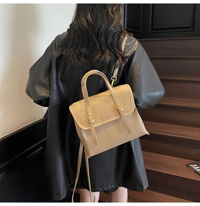 Detail of beige faux leather backpack with vertical straps and gold buckles on cover