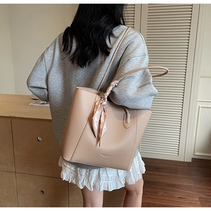 Detail of apricot pebbled leather tote bag with silk scarf on a lifestyle background