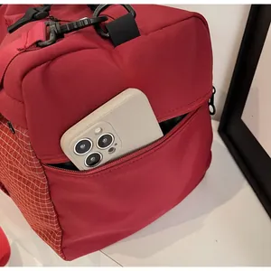 Close-up of red travel bag side zipper pocket showing ample storage space for a phone