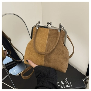 Detail of vintage shell handbag with contrast suede stitching and metallic frame clasp