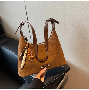 Détail d'un sac à bandoulière en daim givré marron foncé avec perles en bois