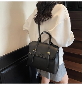 Detail of vintage black leather backpack with metal buckles shown on a model