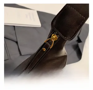 Close-up of golden metal zipper and premium stitching on vintage dark brown leather bag