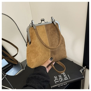Detail of vintage two-tone suede handbag with metallic frame closure and contrast stitching