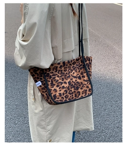 Détail du sac cabas léopard avec étiquette de marque Crown blanche et anses cordes