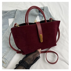 Detail of burgundy matte suede tote bag with vintage gold buckle and leather strap