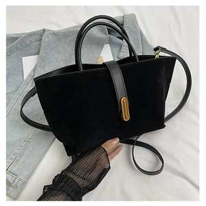 Macro detail of black frosted suede tote bag with gold oval lock and leather straps