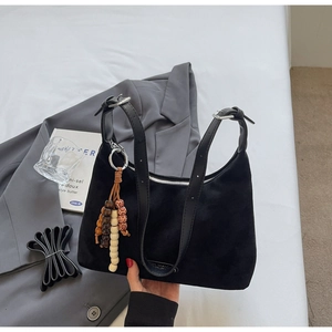 Détail du sac hobo noir en daim avec bandoulières en cuir et breloque en perles bohème