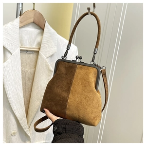 Detail of retro dual-tone suede frame bag showing vintage clasp and textured finish