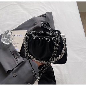Detail view of black pleated dumpling bag with chunky silver chain and zip closure