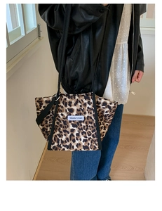 Photo lifestyle d'un grand sac cabas léopard avec bandoulières porté avec veste en cuir