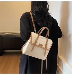 Detail of white and brown leather contrast backpack with metal buckle and fashion logo