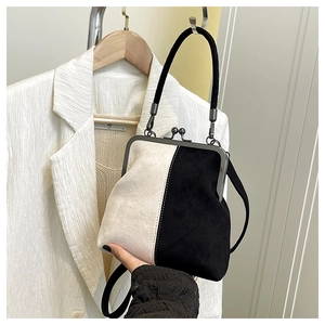Detail of vintage metal clasp and matte suede color-block doctor handbag in white and black