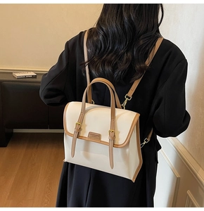 Close-up of retro beige leather backpack with brown trim and gold buckle details