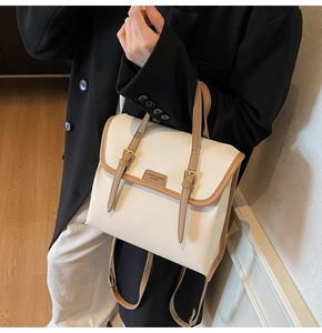 Detail of retro color-block backpack showing cream PU leather texture and gold buckle