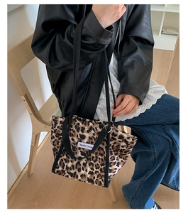 Détail du sac cabas imprimé léopard avec sangles noires et étiquette de marque blanche