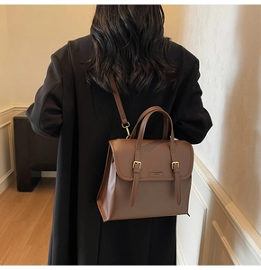 Detail view of the brown vintage textured leather backpack with gold buckle closures